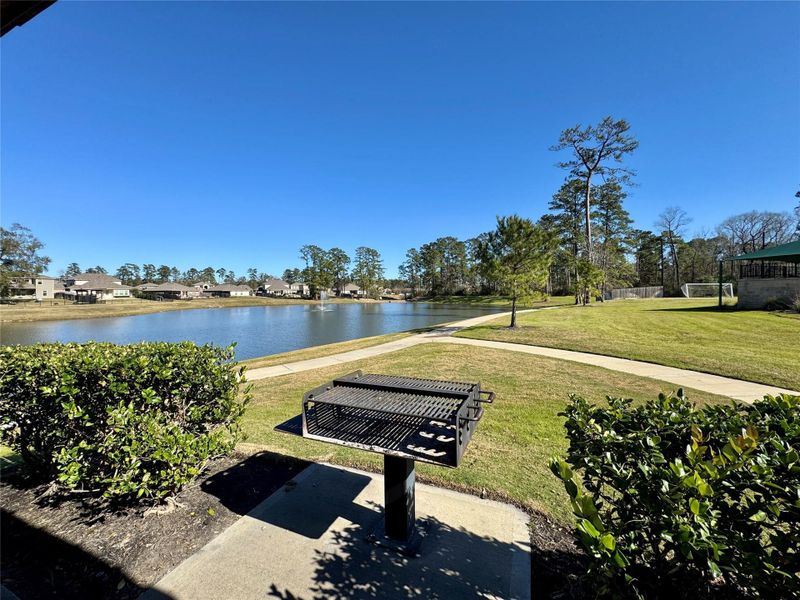 A serene lakeside view with a well-maintained grassy area and a built-in grill. Perfect for outdoor gatherings and enjoying nature. A serene lakeside view with a well-maintained grassy area and a built-in grill. Perfect for outdoor gatherings and enjoying nature.