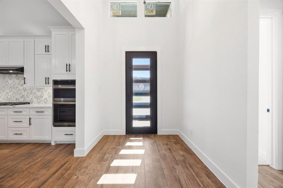 Entryway featuring a contemporary front door with horizontal lites, high ceilings, and clerestory windows Entryway featuring a contemporary front door with horizontal lites, high ceilings, and clerestory windows