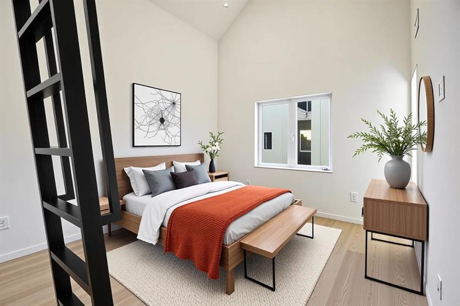 Bedroom featuring light wood finished floors and lofted ceiling