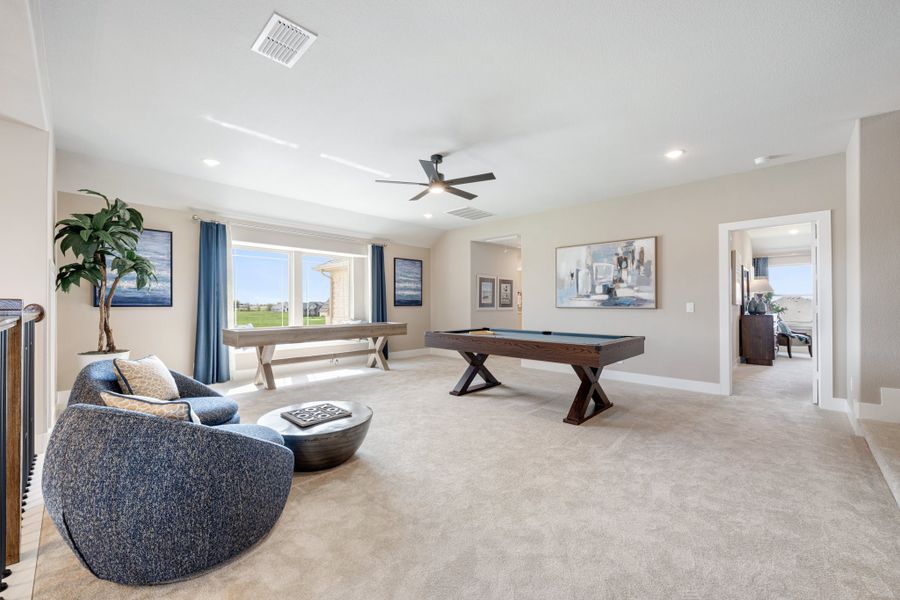 Spacious bonus room with pool table, seating area, carpet flooring, and ceiling fan