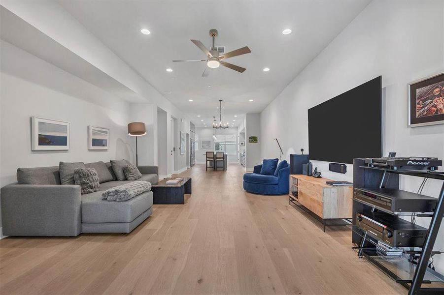 The spacious living room is adorned with expansive windows that flood the area with sunlight, making it an inviting space for family and friends