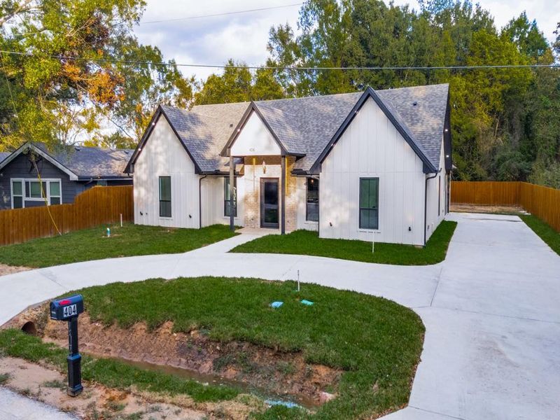 Modern inspired farmhouse with a fenced backyard, and driveway.