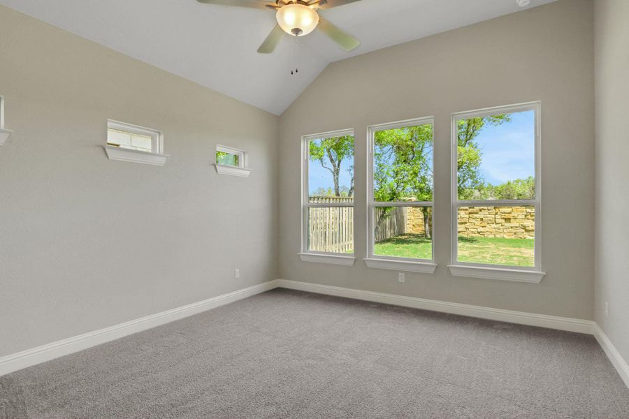 Unfurnished room with ceiling fan, baseboards, carpet flooring, and vaulted ceiling
