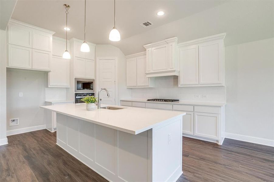 Kitchen featuring an island with sink, white cabinets, appliances with stainless steel finishes, and sink