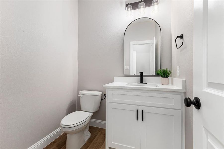 Bathroom featuring toilet, vanity, and hardwood / wood-style flooring