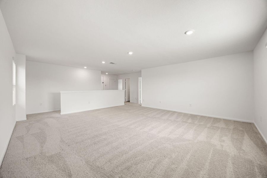 Natural light fills this expansive game room, creating a bright and inviting space for family movie nights, gaming, hobbies, or entertaining.