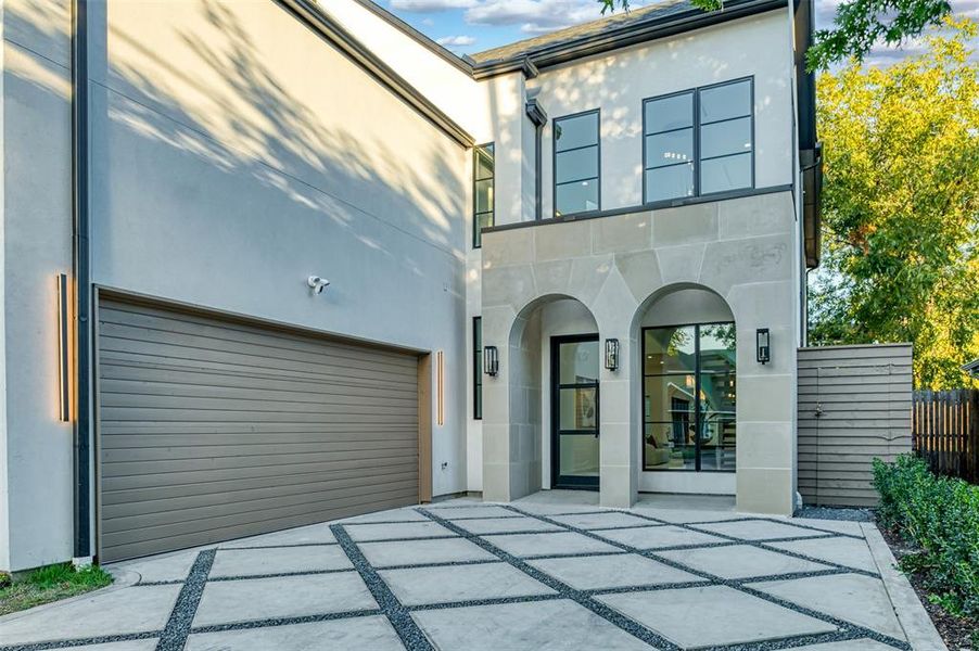 View of front of house featuring stucco siding, a garage, and driveway