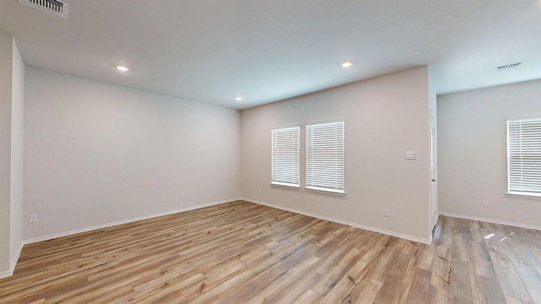 Spacious interior featuring wood-finish flooring, recessed lighting, and multiple windows with blinds Spacious interior featuring wood-finish flooring, recessed lighting, and multiple windows with blinds