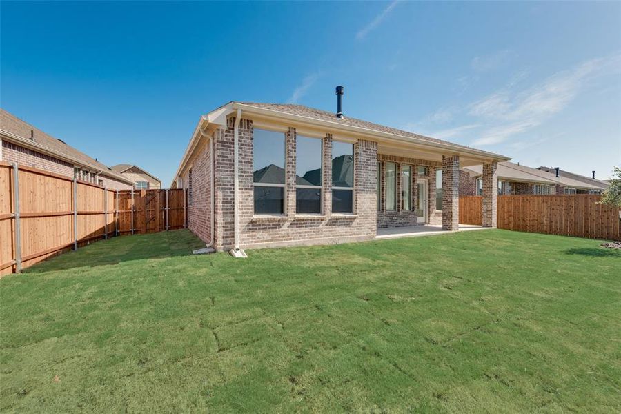 Rear view of property with a lawn and a patio area