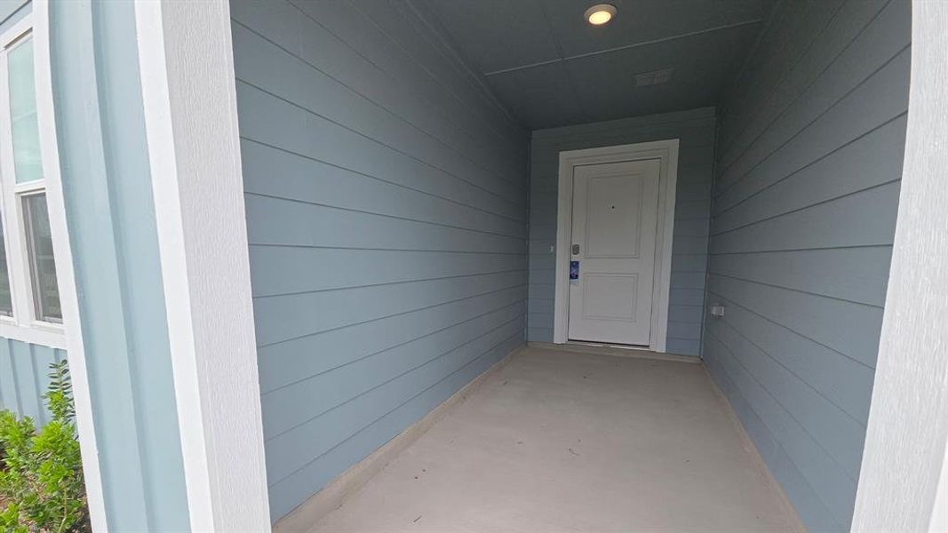 Recessed entry with blue horizontal siding, white trim, and a white paneled door