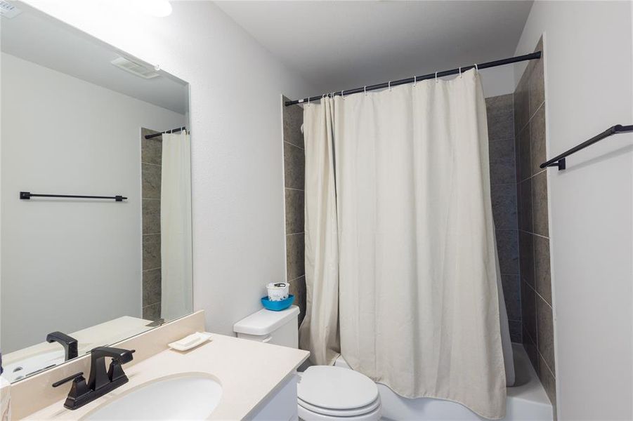 Full bathroom with shower / tub combo with curtain and vanity