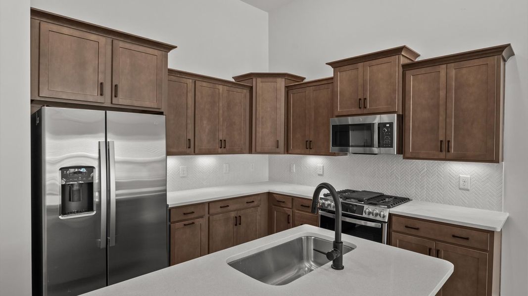 Highly skilled design choices create a clean, open kitchen with a central island
