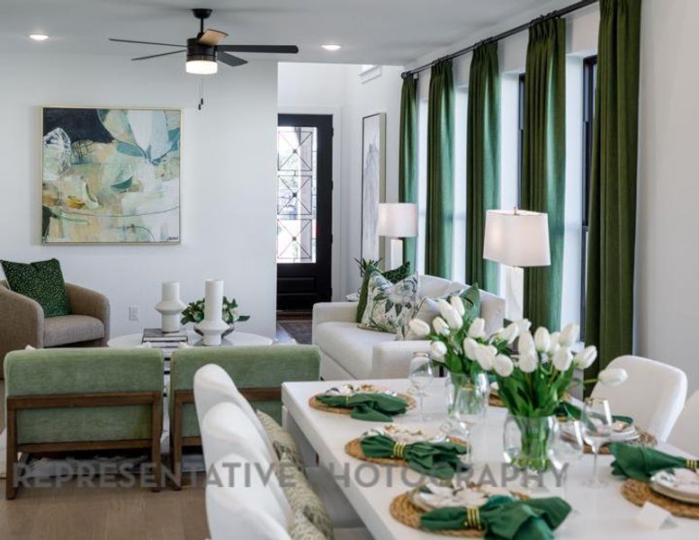 Living area featuring a wealth of natural light, a ceiling fan, and wood finished floors Living area featuring a wealth of natural light, a ceiling fan, and wood finished floors