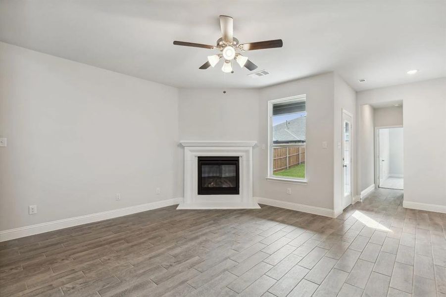 Unfurnished living room with hardwood / wood-style flooring and ceiling fan