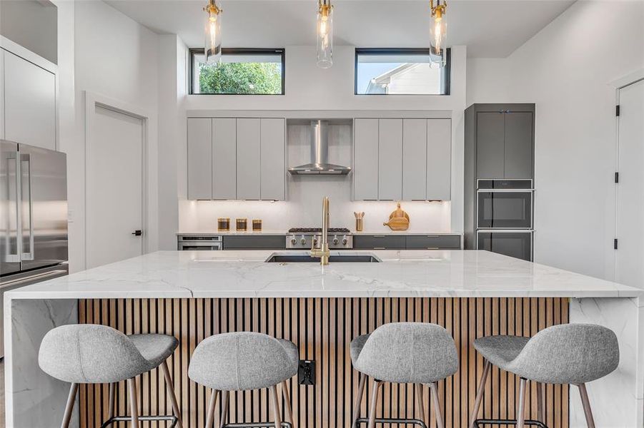 Elevate your culinary experience in this stunning kitchen, complete with marble countertops, custom cabinetry, and luxe gold fixtures.