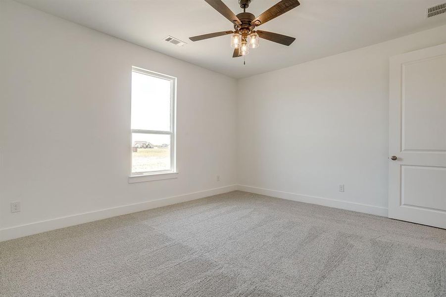 Unfurnished room featuring light colored carpet and a ceiling fan Unfurnished room featuring light colored carpet and a ceiling fan