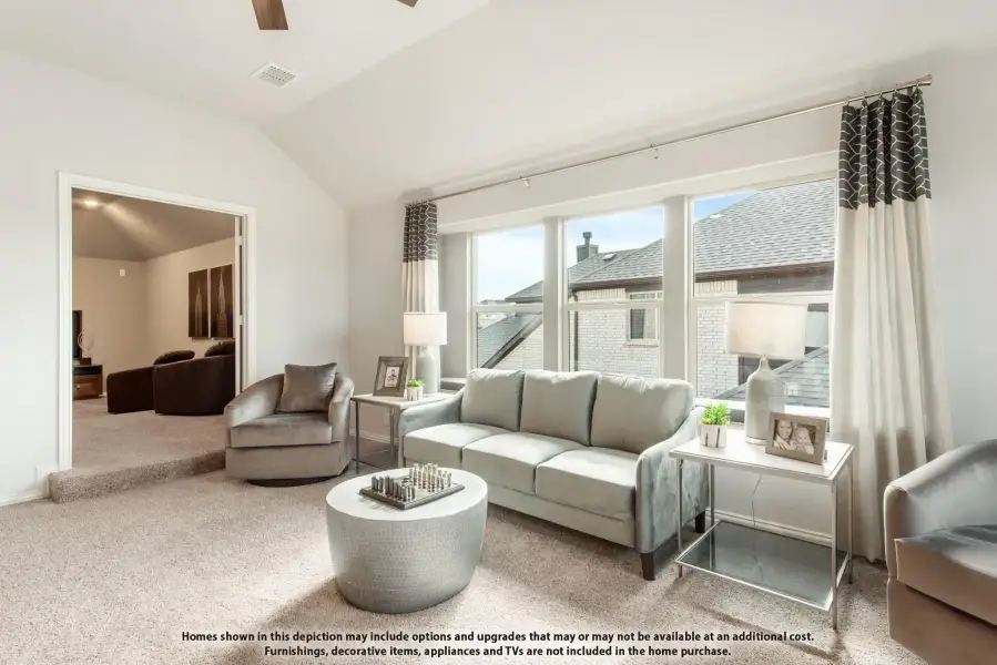 Bright living room with vaulted ceiling, large windows, gray sofa, and carpet flooring Bright living room with vaulted ceiling, large windows, gray sofa, and carpet flooring