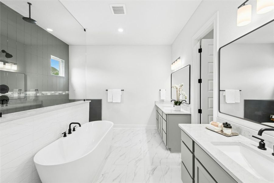 Full bathroom with a freestanding bath, two vanities, walk in shower, light marble finish floors, and recessed lighting Full bathroom with a freestanding bath, two vanities, walk in shower, light marble finish floors, and recessed lighting