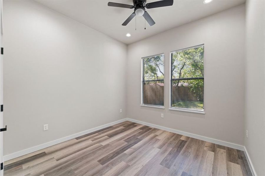 Empty room with ceiling fan and light hardwood / wood-style floors