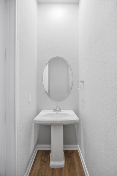 Bathroom with dark wood finished floors and a textured wall