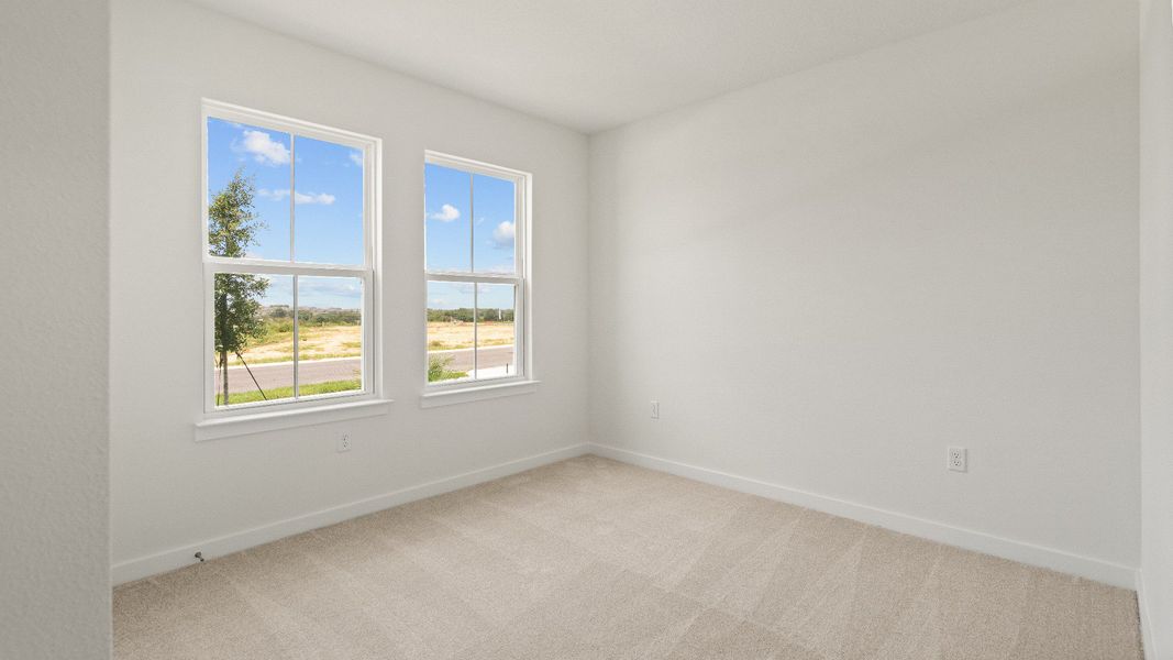 Bright bedroom with plush carpet, double-door closet, and natural light in the Castaway model
