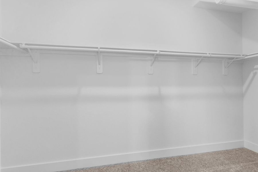 Spacious walk-in closet off the primary suite with ample hanging space and shelving — a true wardrobe dream. **Image Representative of Plan Only and May Vary as Built**.