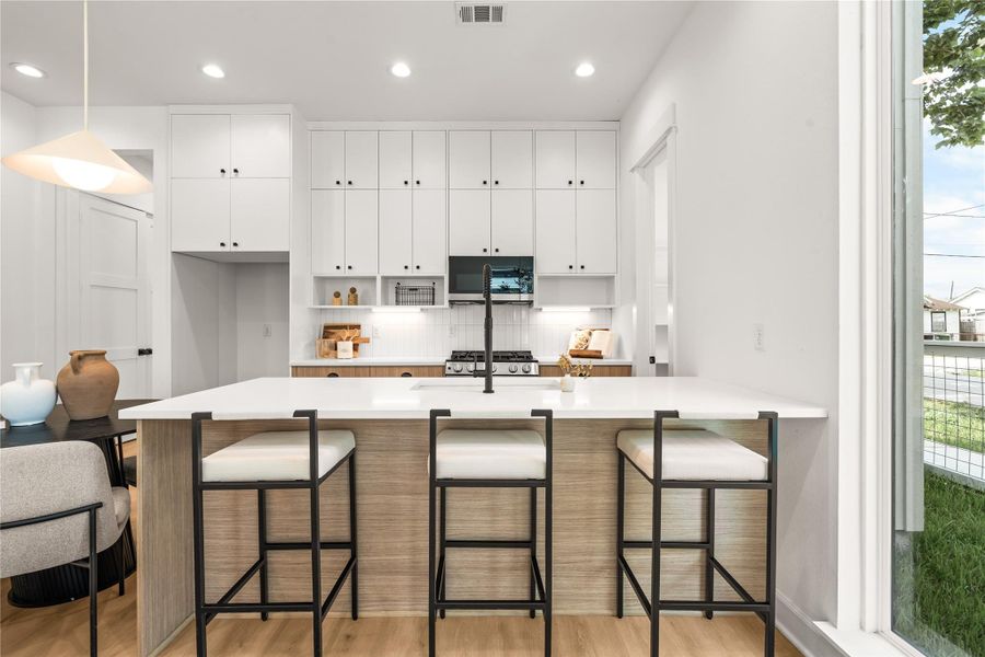 Kitchen island with breakfast bar seating — the anchor of a main floor built for real life Kitchen island with breakfast bar seating — the anchor of a main floor built for real life