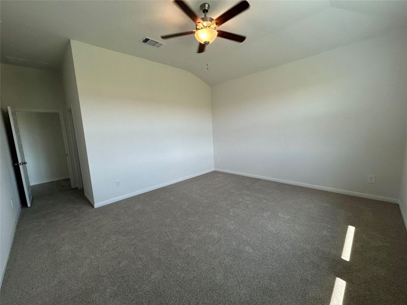 Carpeted spare room with vaulted ceiling and ceiling fan Carpeted spare room with vaulted ceiling and ceiling fan