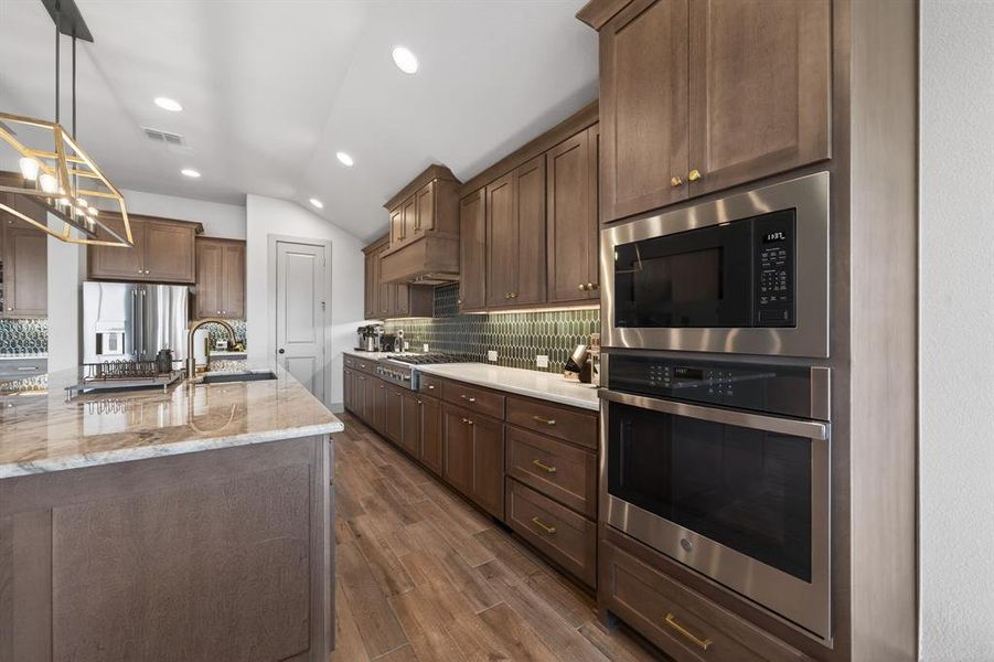 Designer kitchen with stainless appliances, custom cabinetry and stylish backsplash. Designer kitchen with stainless appliances, custom cabinetry and stylish backsplash.