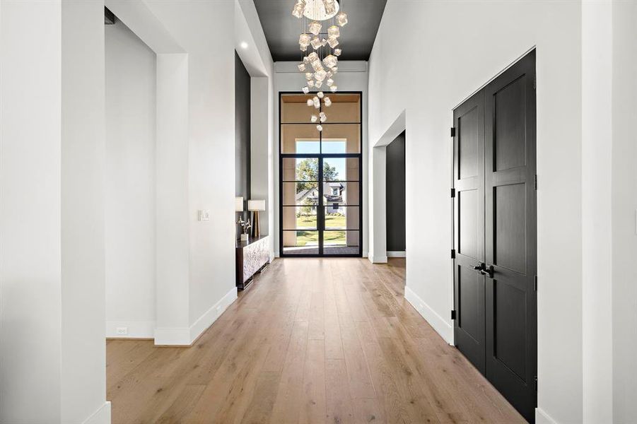 Upon entering, you are welcomed by a remarkable 16-foot custom metal and glass front door,