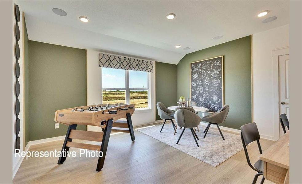 Spacious bonus room featuring wood-finish flooring, recessed lighting, and a large window with a patterned valance