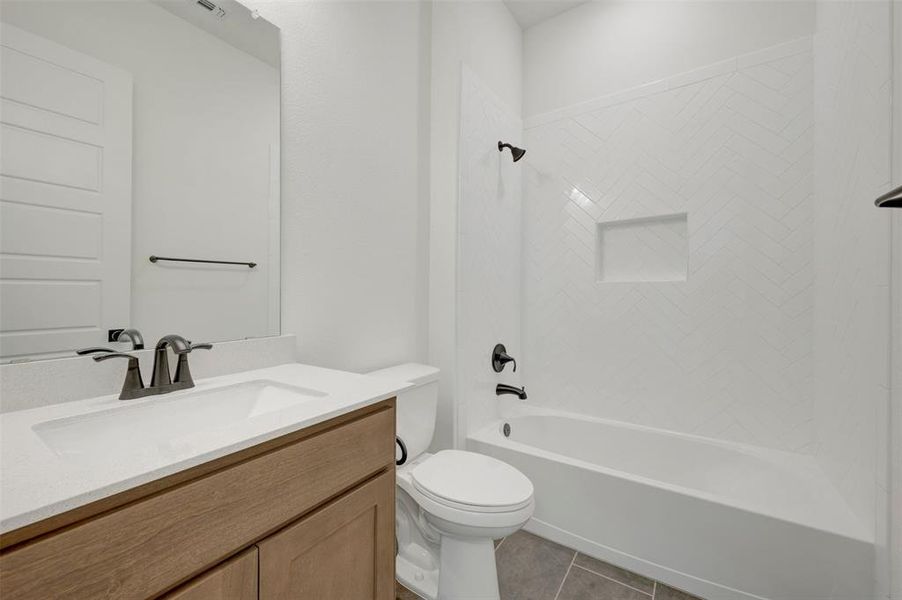 Bathroom featuring a wood-finish vanity with an integrated sink and light-toned countertop Bathroom featuring a wood-finish vanity with an integrated sink and light-toned countertop