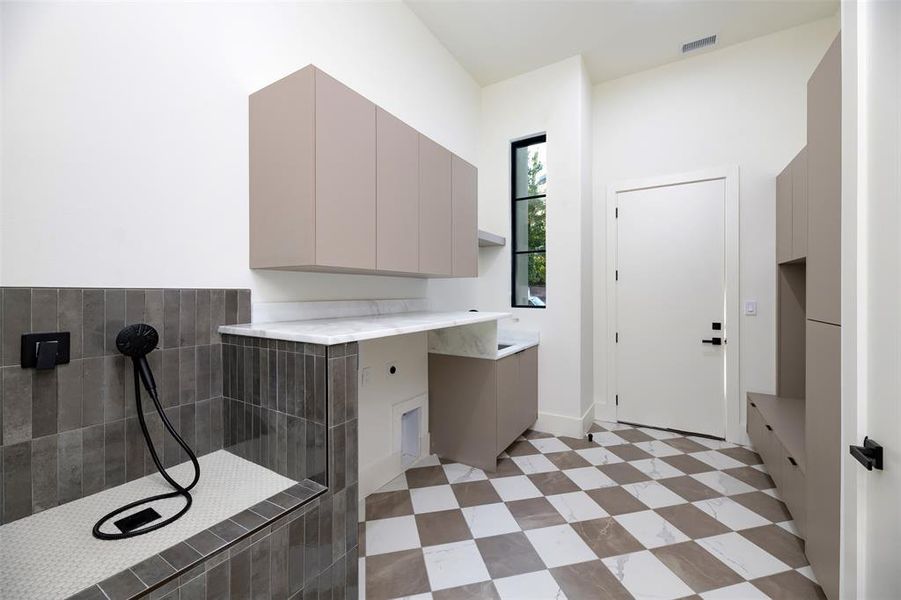 Laundry area featuring electric dryer hookup and dog bathing station