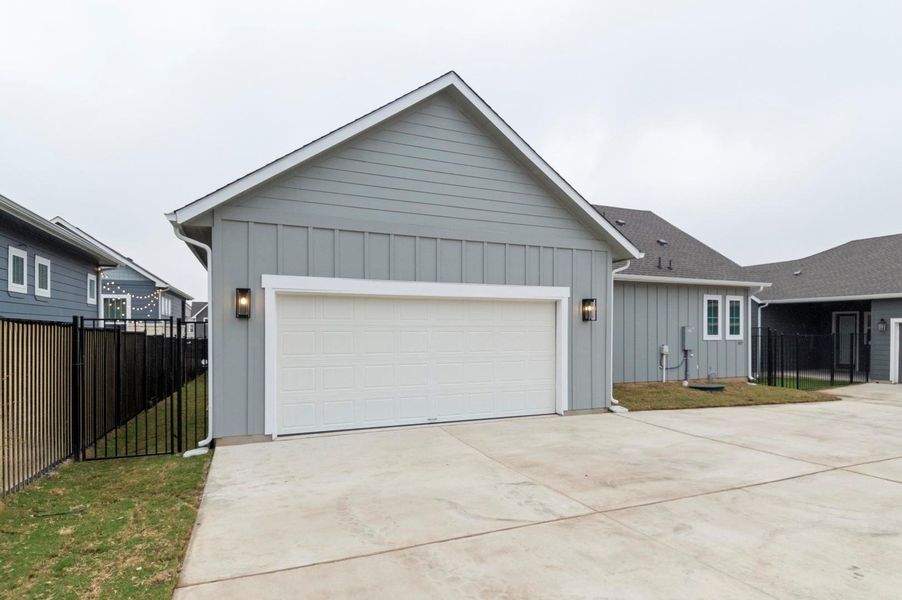 Single story home featuring board and batten siding, driveway, and an attached garage