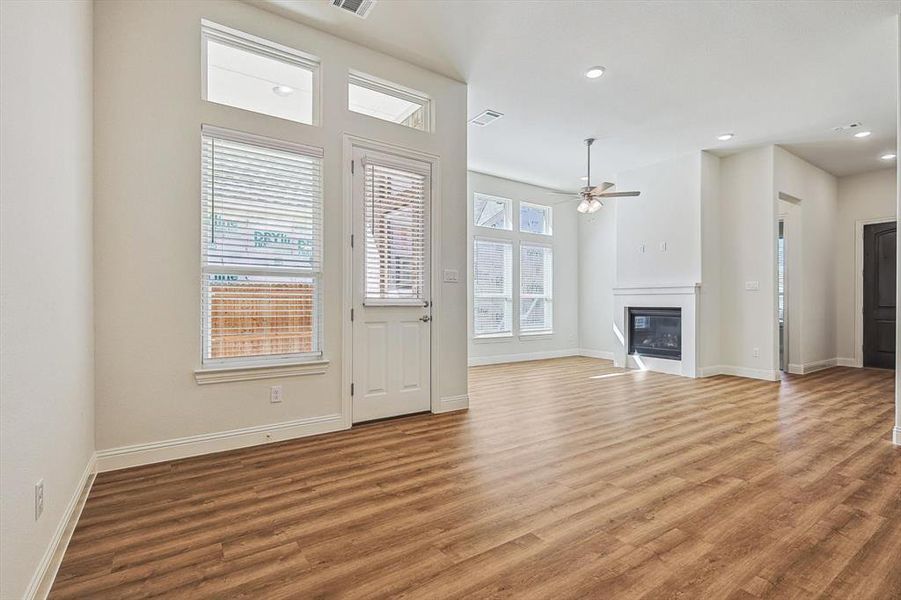 Unfurnished living room with ceiling fan and hardwood / wood-style flooring