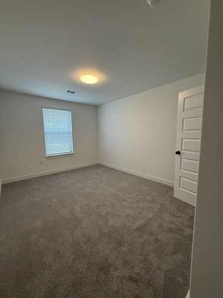 Spare room featuring carpet flooring and baseboards