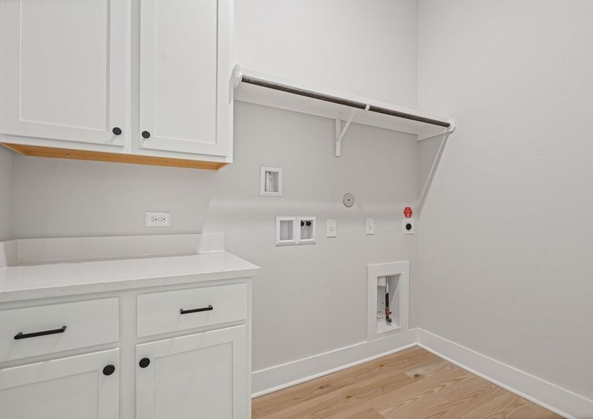 The laundry room has hanging space and cabinet space.