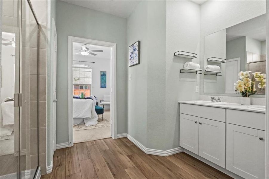 Full bathroom featuring a stall shower, dark wood finished floors, double vanity, ensuite bathroom, and ceiling fan Full bathroom featuring a stall shower, dark wood finished floors, double vanity, ensuite bathroom, and ceiling fan