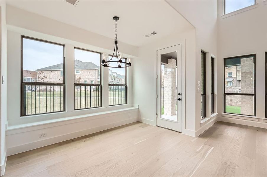 Unfurnished dining area featuring light wood-type flooring and an inviting chandelier