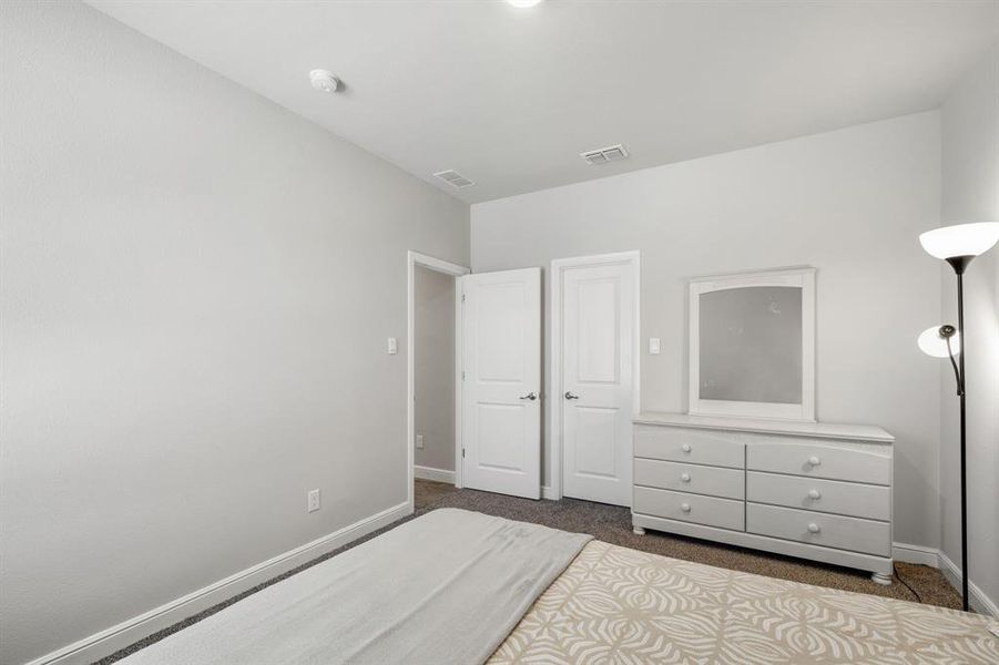Bedroom featuring dark colored carpet and baseboards
