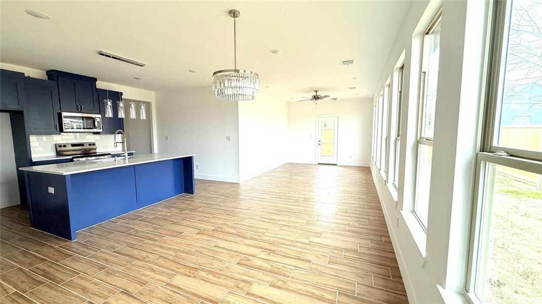 Kitchen with visible vents, wood finish floors, stainless steel appliances, decorative backsplash, and light countertops