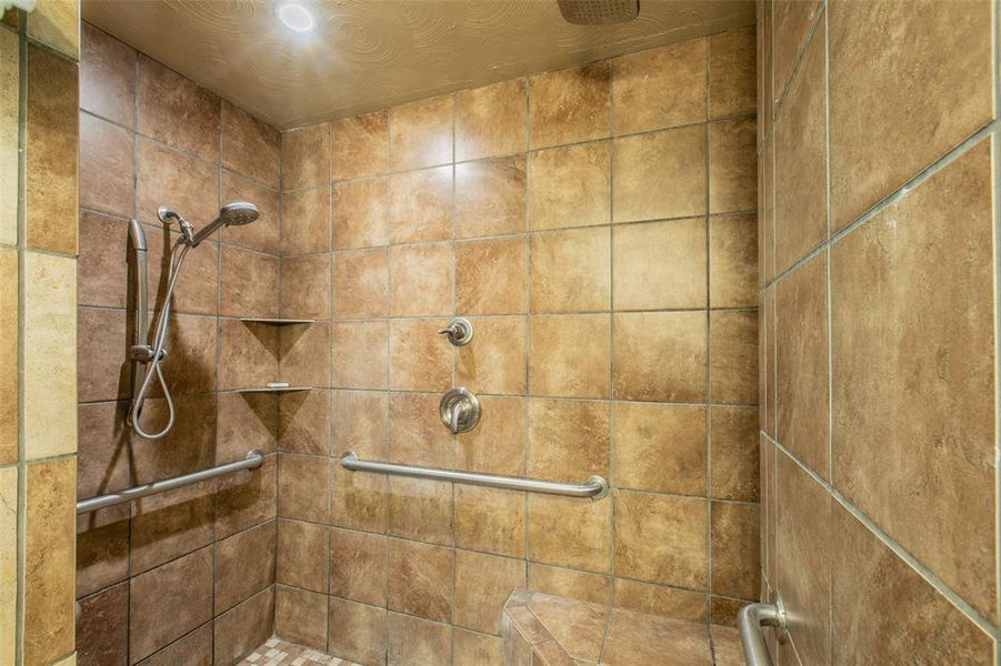Spacious walk-in shower with dual shower heads, built-in seating, and accessibility features. Spacious walk-in shower with dual shower heads, built-in seating, and accessibility features.