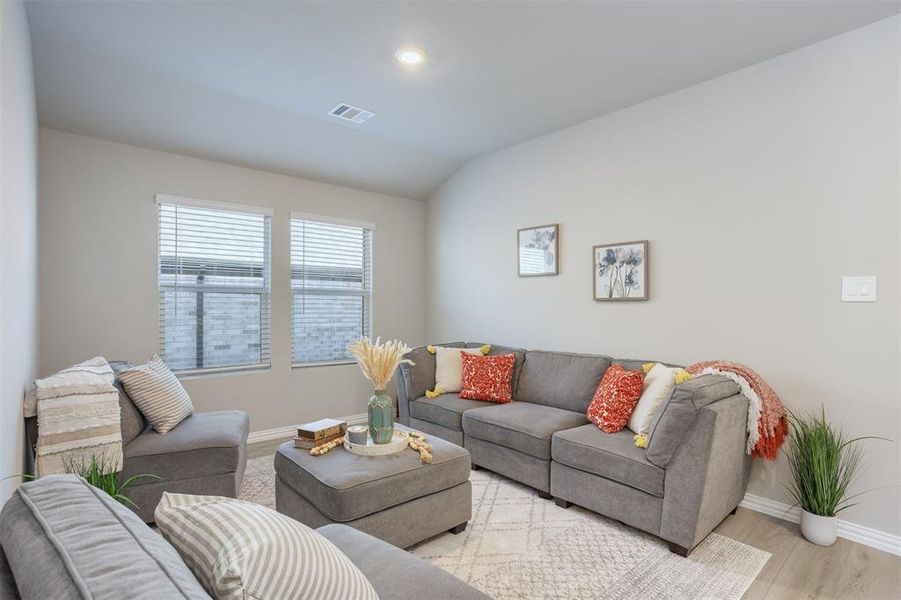Living room featuring wood finished floors and vaulted ceiling Living room featuring wood finished floors and vaulted ceiling