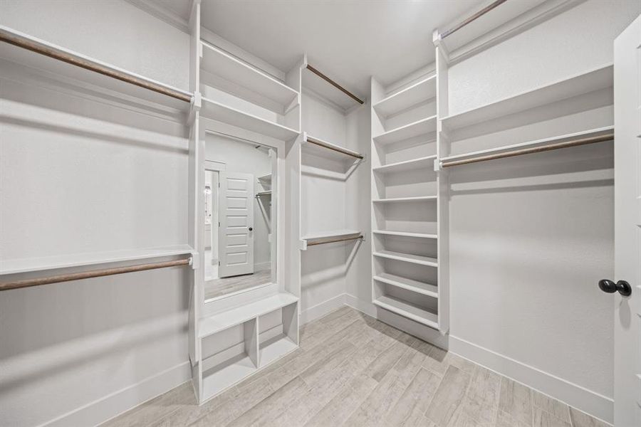 Walk in closet with light wood-style flooring