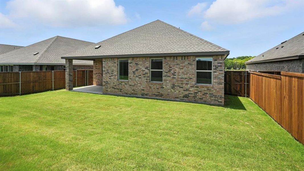 Rear view of house featuring brick siding, a shingled roof, and a fenced backyard Rear view of house featuring brick siding, a shingled roof, and a fenced backyard