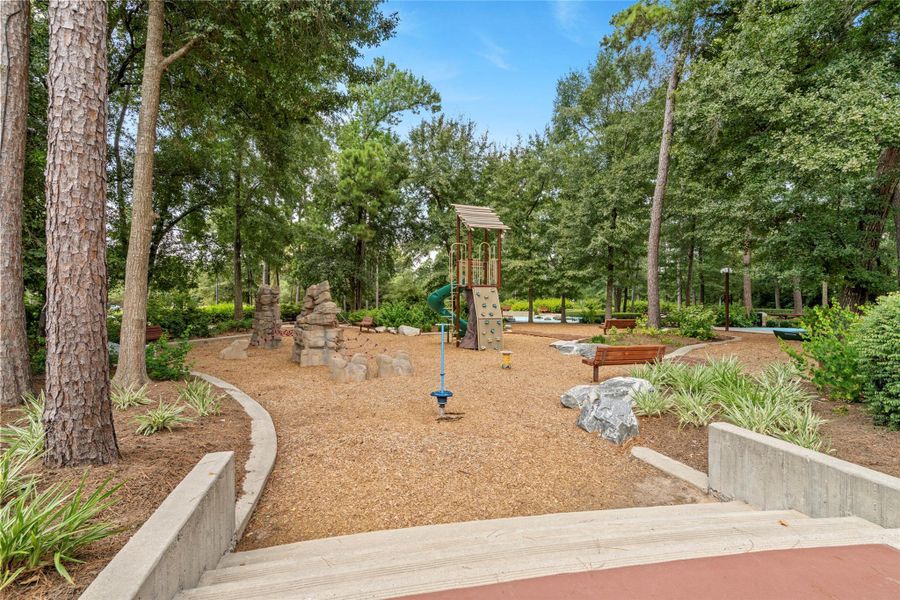 Wooded children's playground and nature-inspired play area available to residents of The Groves.