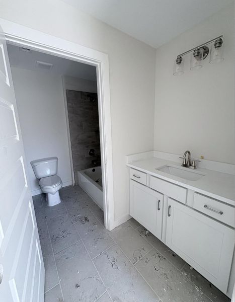 White shaker-style vanity with a light-toned countertop, undermount sink, and brushed nickel faucet White shaker-style vanity with a light-toned countertop, undermount sink, and brushed nickel faucet