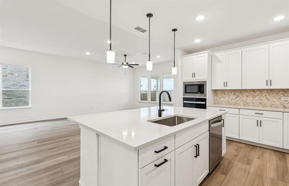 Spacious eat-in kitchen designed with a large island for dining  *Real home pictured