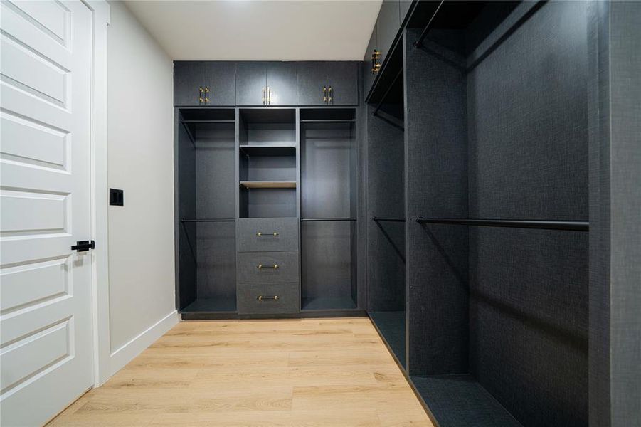 Walk in closet featuring light wood finished floors Walk in closet featuring light wood finished floors