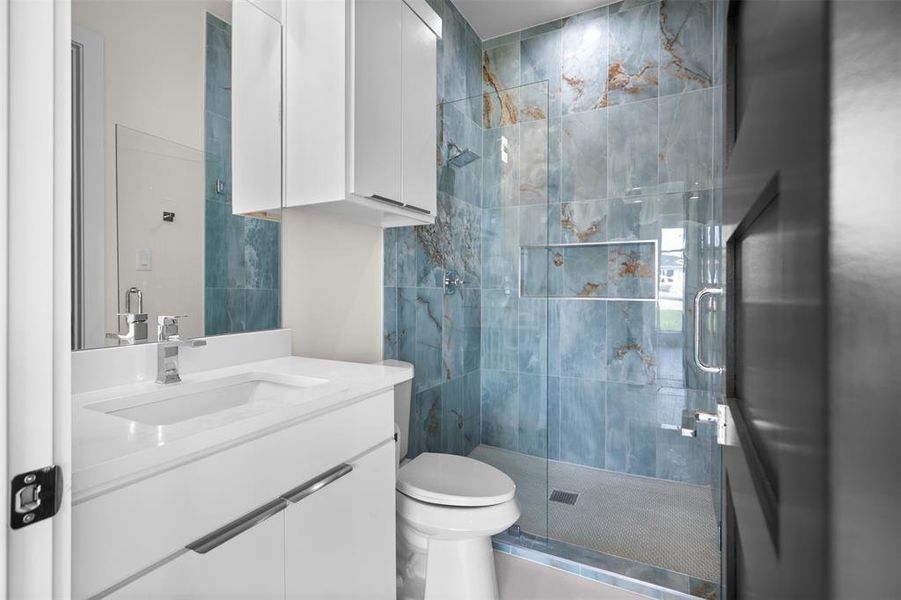 This bathroom features a contemporary vanity with a white countertop and a sleek, integrated sink This bathroom features a contemporary vanity with a white countertop and a sleek, integrated sink